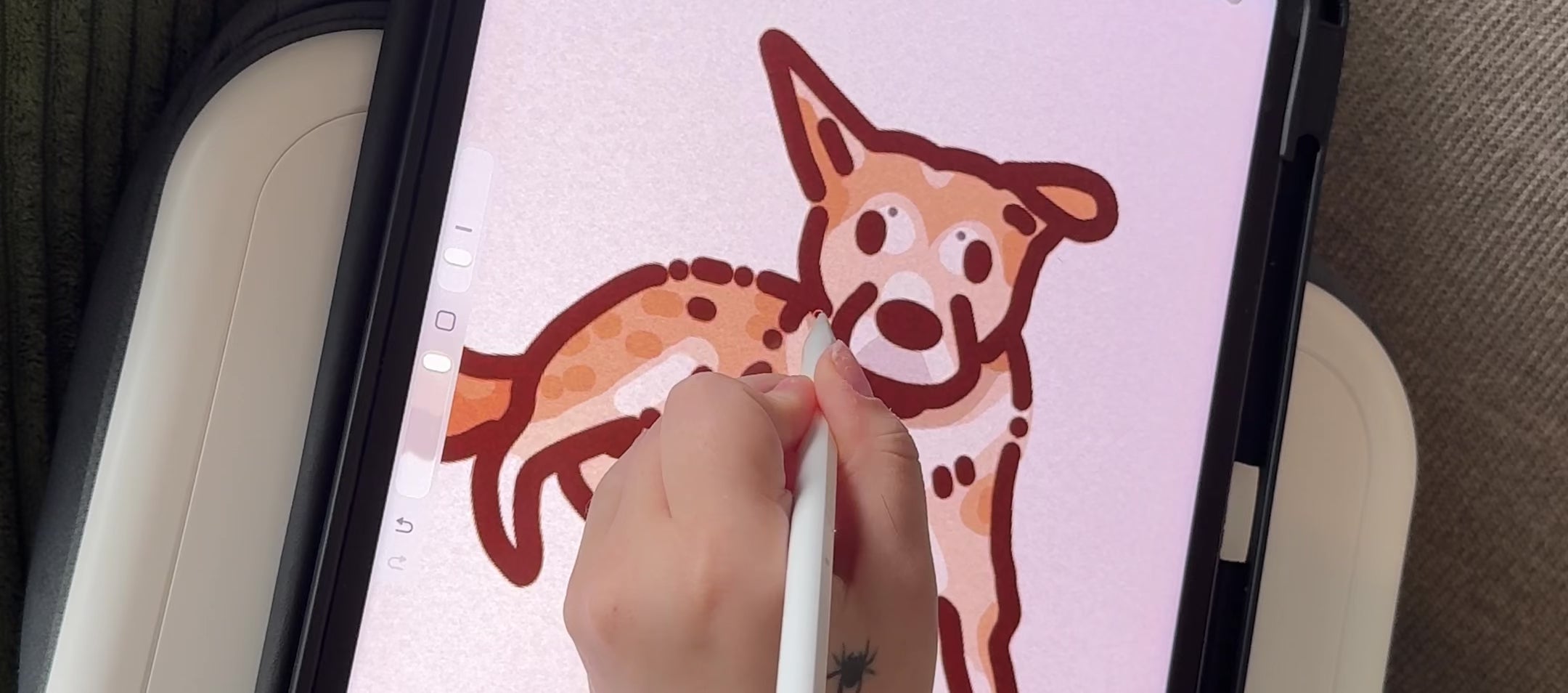 Load video: a female hand is using an apple pencil &amp; an Ipad to hand-draw a portrait of a cream-colored dog, very stylized with large eyes